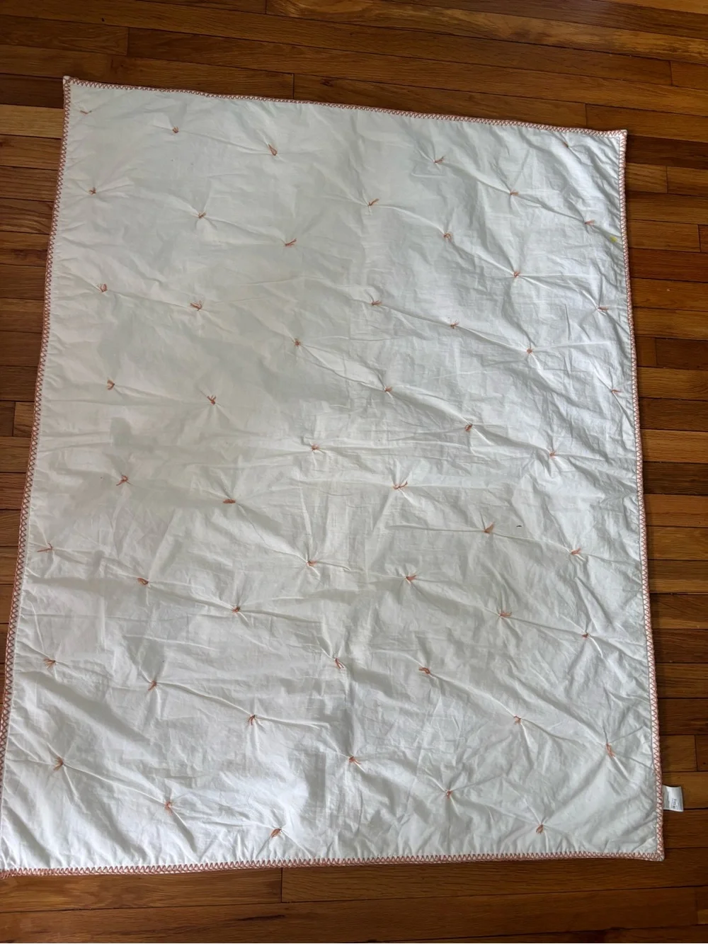 Crate and Barrel, Crate and Kids mini tufted crib quilt. Peach color